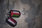 army blank, dog tag with flag of oman and yemen on the khaki texture background.