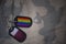 army blank, dog tag with flag of qatar and gay rainbow flag on the khaki texture background.