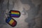 army blank, dog tag with flag of romania and gay rainbow flag on the khaki texture background.