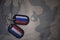 army blank, dog tag with flag of russia and netherlands on the khaki texture background.
