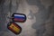 army blank, dog tag with flag of russia and spain on the khaki texture background.