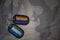 army blank, dog tag with flag of sierra leone and gay rainbow flag on the khaki texture background.