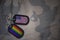 army blank, dog tag with flag of united states of america and gay rainbow flag on the khaki texture background.