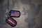 army blank, dog tag with flag of united states of america and latvia on the khaki texture background.