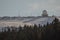 Army or rain radar on top of the hill. Domed radar in white color on a top of a mountain covered with snow