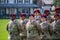 Army soldiers in the airborne division wearing their military camouflage and red berets stand at ease on the parade field