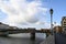 The Arno river of Pisa in Tuscany with a cloudy sky clouds