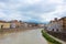 The Arno River and the small Gothic church of Santa Maria della Spina on the waterfront of Pisa. Cloudy, rainy weather.