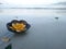 Aroma candle in coconut shell floating on the beach.