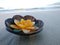 Aroma candle in coconut shell floating on the beach.