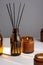 Aroma diffuser with natural essential oil in brown glass bottle, soy wax candle with fire in a Amber jar on a white gray
