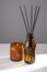 Aroma diffuser with natural essential oil in brown glass refill packaging bottle, soy wax candle with fire in a Amber jar on a