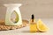 Aroma lamp, essential oil and lemon slice on wooden table. Space for text