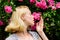 Aroma of roses. Girl adorable blonde sniffing fragrance of pink bloom. Spring and summer. Perfume and cosmetics. Woman
