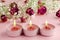 Aromatherapy concept. Three burning candles and dry roses on pink