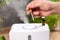 Aromatherapy Essential Oil Home Diffuser. Man Hand Adding Natural Aromatic Essential Oil into Air Humidifier
