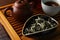 Aromatic Baihao Yinzhen tea and teapot on wooden tray, closeup. Traditional ceremony