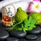 Aromatic concept of bergamot fruits, fresh mint, rosemary, candles, towels, flower and bottles essential oil on zen stones