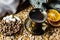 Aromatic dark coffee with bubbles on the surface in a dark gold Cup on a saucer, next to whole grains, peeled and dried oranges