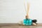 Aromatic reed freshener, spa stones and sea shells on wooden table against light background.