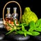Aromatic spa of bottles essential oil in basket, fresh mint, rosemary and bergamot fruits on black zen basalt stones with