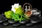 Aromatic spa of bottles essential oil in basket, fresh mint, rosemary, bergamot fruits, flower and candles on black zen stones