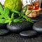 Aromatic spa still life of bottles essential oil, fresh mint, rosemary, bergamot fruits, towels and candles on zen stones