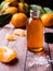 Aromatic tangerine oil, with tangerines on a wooden background, selective focus