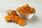 Aromatic turmeric powder and raw root on white table, closeup
