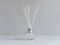 Aromatizer. Aromatic air freshener in a transparent glass bottle with white reeds on a gray background