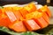 Arrange fresh yellow papaya on green leaf dish