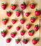 Arranged pattern of strawberries on a wooden board