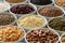 Arranged white bowls with uncooked pulses, grains and seeds on w