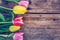 Arrangement of colorful tulips on a rustic wooden table, text space