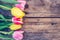 Arrangement of colorful tulips on a rustic wooden table, text space