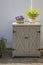 Arrangement of daffodils (narcissus) and homet violets (viola comuta) on a little cabinet