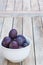 Arrangement of damson plums on wooden boards