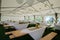 Arrangement dinner in a tent with wooden tables and benches. Decorated with sunflowers, candles and balloons