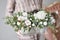 Arrangement of fresh spruce in a metal pot in womans hands. European Flowers shop. Christmas mood.