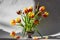 Arrangement of red and yellow tulip flowers on pin frog in vintage vase. Spring ikebana decor with japanese kenzan.