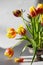 Arrangement of red and yellow tulip flowers on pin frog in vintage vase. Spring ikebana decor with japanese kenzan.