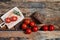 Arrangement of shiny ripe tomatoes on branch with wholegrain bread on wooden planks