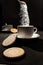 Arrangement of white cups, several cookies and levitating sugar cubes