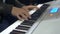 Arranger hands playing keyboards in recording studio for music production concept - closeup