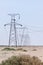 Array of electric pylons on a clear sky in desert