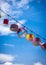 Array of hanging lamps suspended from a wire against a clear and vibrant blue sky