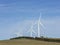 An array of large wind turbines moving to create kinetic energy for renewable energy supply