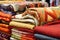 an array of patterned, handmade quilts draped over a rack