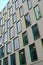 Array of rectangular windows with colorful frames in yellow, green, cyan and blue on gray modern facade of Vicki Sara Building