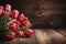 Array of red tulips against wooden backdrop open area for text